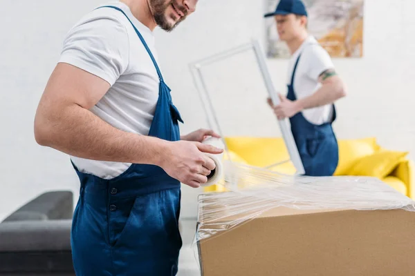 Cropped View Mover Uniform Wrapping Cardboard Box Stretch Film Apartment — Stock Photo, Image