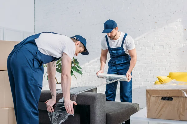 Movers Wrapping Couch Roll Stretch Film Apartment — Stock Photo, Image