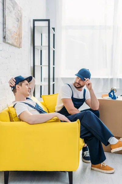 Two Movers Uniform Sitting Couch Apartment — Stock Photo, Image