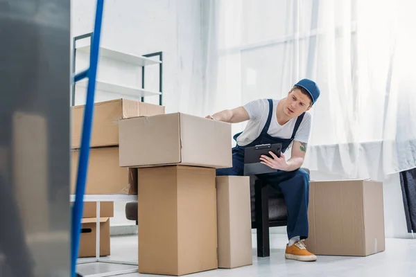 Mover Sitting Cardboard Boxes Holding Clipboard Apartment — Stock Photo, Image