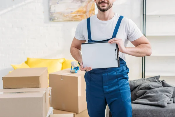 Bijgesneden Weergave Van Mover Met Lege Klembord Buurt Van Kartonnen — Stockfoto