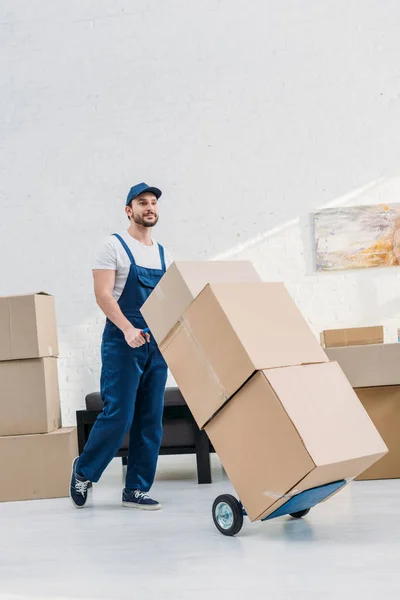 Mover Uniform Transporting Cardboard Boxes Hand Truck Apartment Copy Space — Stock Photo, Image