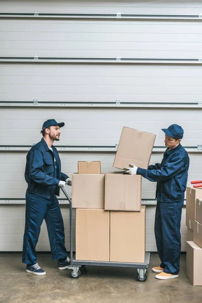 Two Movers Uniform Transporting Cardboard Boxes Hand Truck Warehouse Copy — Stock Photo, Image