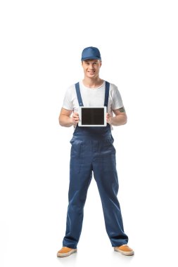 smiling mover looking at camera and presenting digital tablet with blank screen isolated on white clipart