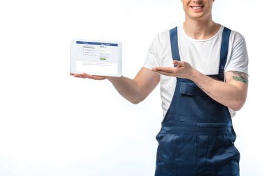 gülümseyen Taşıyıcı hareket ve beyaz üzerinde yalıtılmış ekranda Facebook uygulaması ile dijital tablet sunan kırpılmış görünümü