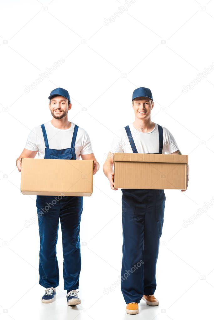 two handsome movers looking at camera while transporting cardboard boxes on white