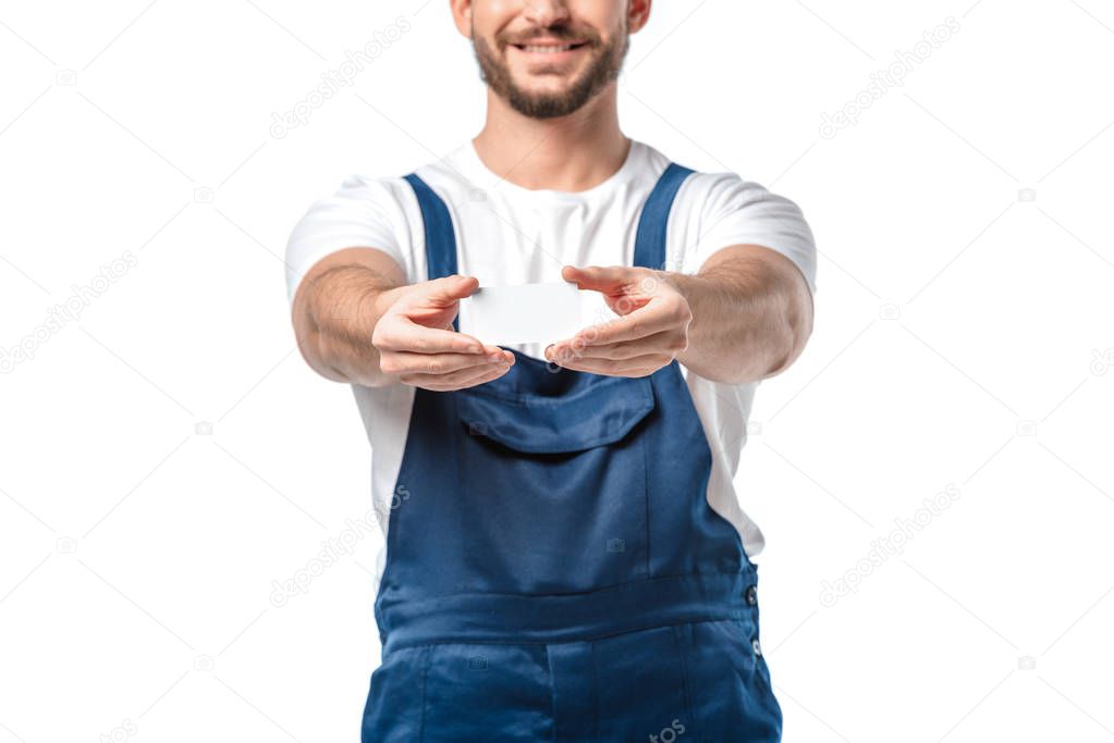 partial view of smiling mover in uniform holding blank business card isolated on white