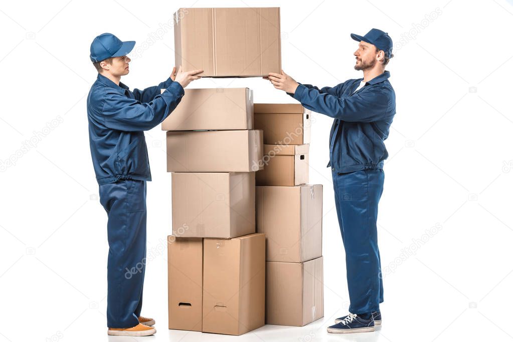 two movers in uniform holding cardboard box on white 