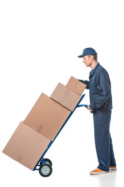 mover in uniform transporting cardboard boxes on hand truck isolated on white with copy space clipart