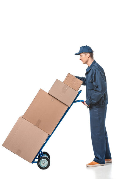 mover in uniform transporting cardboard boxes on hand truck isolated on white with copy space