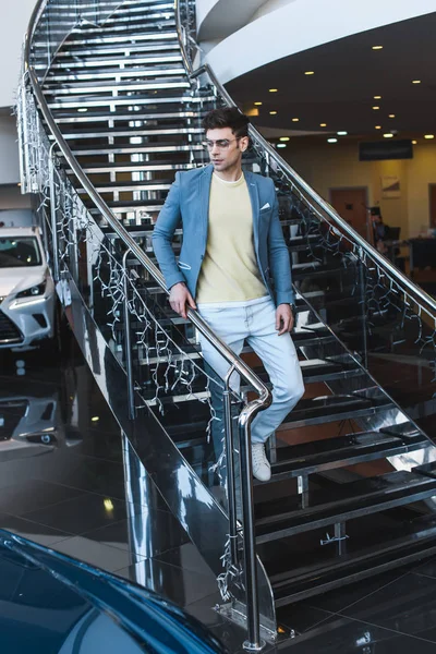 Stylowy Człowiek Okularach Chodzenie Schodach Salonie Samochodowym — Zdjęcie stockowe
