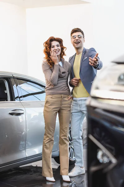 Selective Focus Cheerful Curly Woman Standing Happy Man Pointing Finger — Stock Photo, Image
