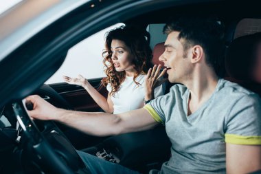 Otomobil adam yakın otururken, kıvırcık kadın işaret seçici odak 