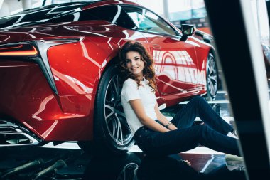 Araba showroom yeni lüks araba yakın oturan mutlu kadın seçici odak