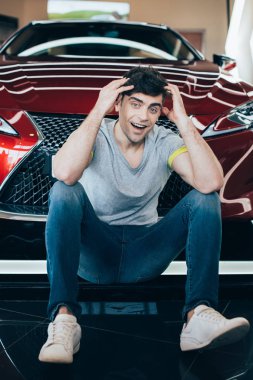 Yeni kırmızı lüks araba yakın oturan yakışıklı heyecanlı adam 