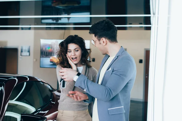 Cheerful Man Holding Keys Surprised Curly Girl While Standing Red — Stock Photo, Image