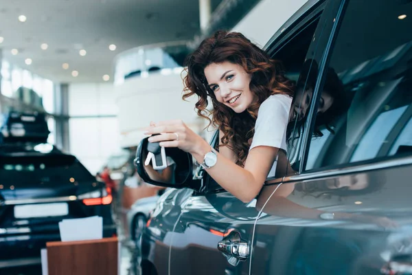 Вибірковий Фокус Щасливої Кучерявої Жінки Тримає Ключі Дивлячись Вікна Автомобілі — стокове фото