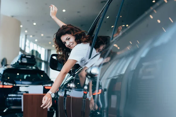 Selective Focus Cheerful Curly Woman Gesturing While Looking Out Window — Stock Photo, Image