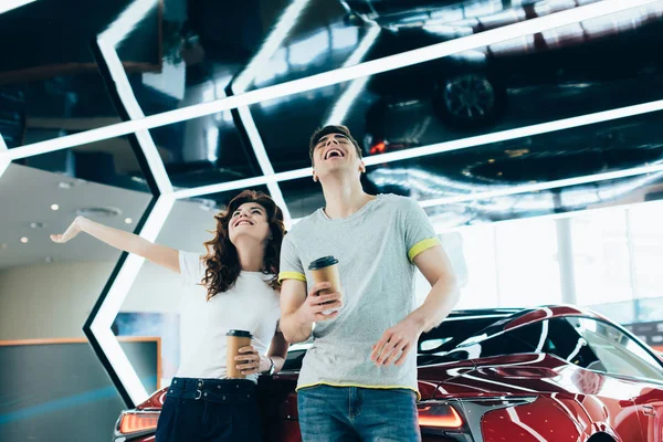 Homem Feliz Mulher Rindo Enquanto Segurando Copos Papel Perto Automóvel — Fotografia de Stock