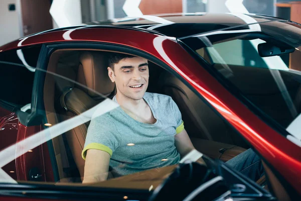 Enfoque Selectivo Hombre Sonriente Guapo Sentado Nuevo Coche Rojo — Foto de Stock