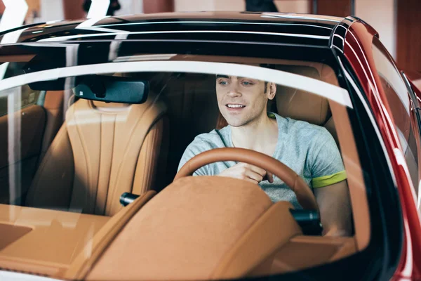 选择焦点英俊的快乐的男人坐在方向盘上的新车 — 图库照片
