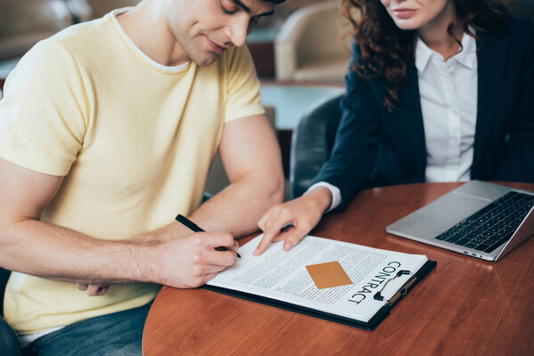 избирательный фокус счастливого человека подписания контракта рядом с автодилером
