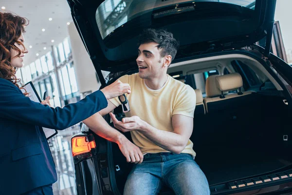 Pretty Car Dealer Giving Car Keys Happy Man Sitting New — Stock Photo, Image