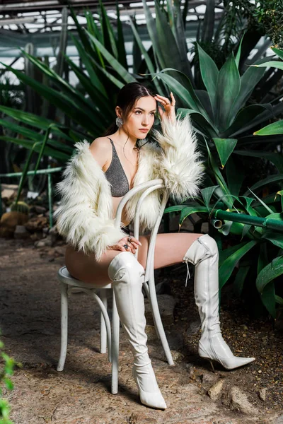 Mujer Sexy Abrigo Piel Sintética Botas Blancas Sentadas Silla Naranjería — Foto de Stock