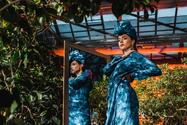 Mooie Vrouw Blauwe Tulband Jurk Permanent Buurt Van Spiegel Oranjerie — Stockfoto