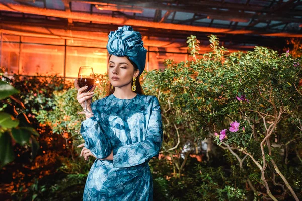 Aantrekkelijke Vrouw Blauwe Tulband Glas Rode Wijn Houden Oranjerie — Stockfoto