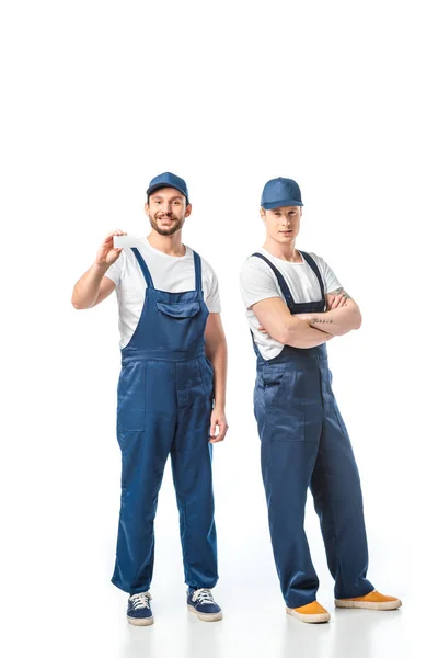 Movers Uniforme Mirando Cámara Mostrando Tarjeta Con Espacio Copia Blanco — Foto de Stock