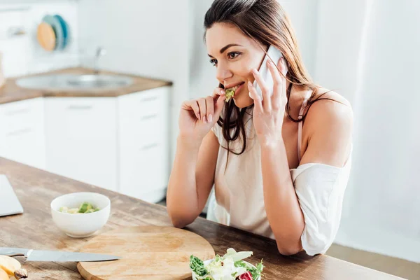 Pretty Girl Eating Salad Talking Smartphone Kitchen — Stock Photo, Image