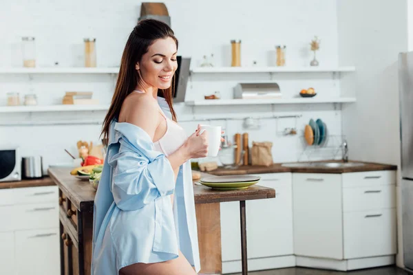微笑性感的女孩在白色内衣举行一杯咖啡在厨房 — 图库照片