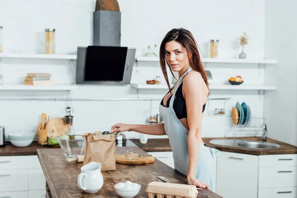 Mujer Interesada Ropa Interior Delantal Pie Cerca Mesa Madera Cocina — Foto de Stock