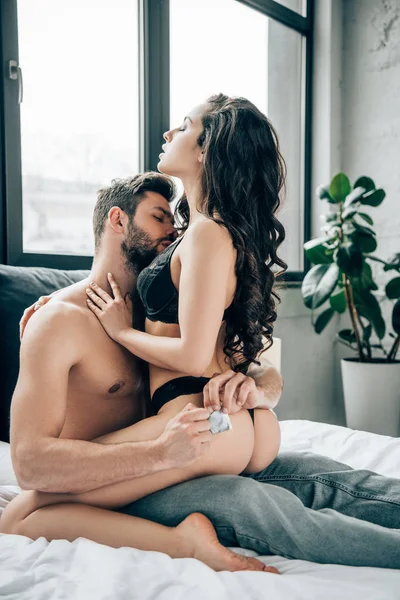 Leidenschaftliche Frau Unterwäsche Berührt Mann Mit Kondom Der Hand — Stockfoto