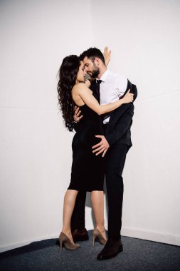 çekici esmer kadın soyunma yakışıklı adamın yanında beyaz duvar 