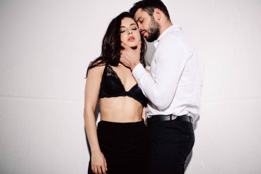 yakışıklı adam beyaz üzerine siyah sütyen ayakta seksi kadın yüzü dokunmadan 