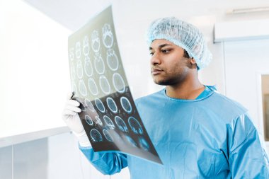 Tıbbi kap ve üniforma tutarak ve x-ışını görünümlü yakışıklı Doktor 