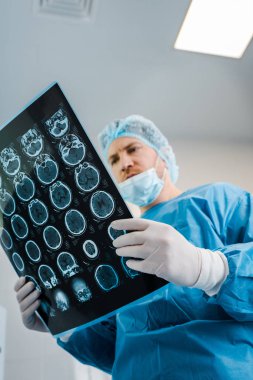 Tıbbi kapak ve üniforma tutarak klinikte yakışıklı Doktor düşük açı görünümü 