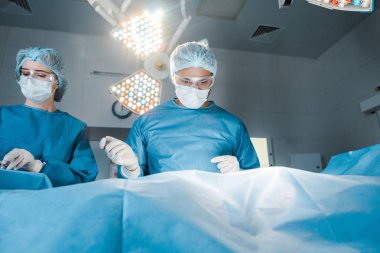 Hemşire ve cerrah üniforma ve Tıbbi maskeler operasyonu yapıyor 