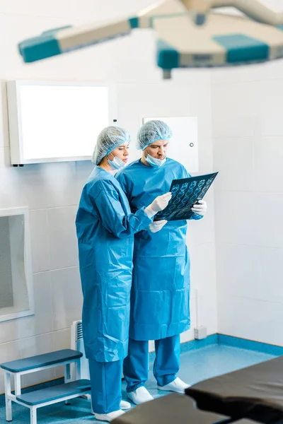 Médicos Bonitos Bonitos Uniformes Segurando Raio Falando Clínica — Fotografia de Stock