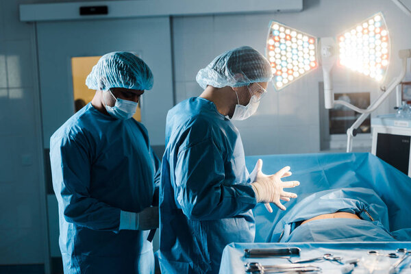 nurse and doctor in uniforms and medical masks in operating room