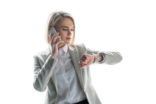 严重的女商人在智能手机上交谈和检查时间手表隔离在白色 — 图库照片