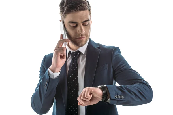 ハンサムなビジネスマンがスマートフォンで話し 白で孤立した時計を見て — ストック写真