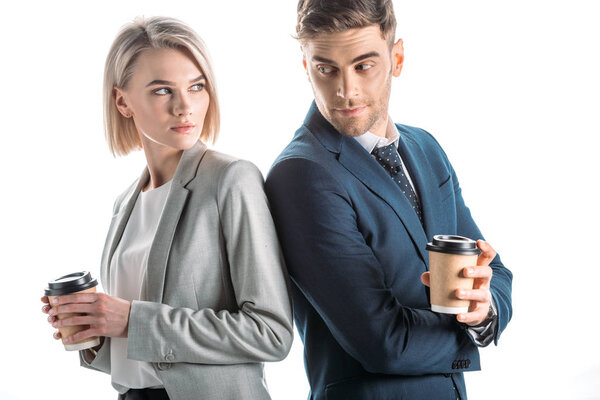 молодые деловые партнеры стоя спиной к спине и держа одноразовые чашки изолированы на белом
