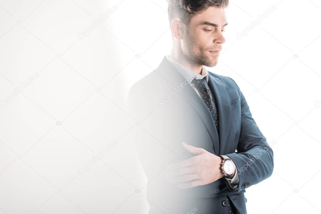 selective focus of confident businessman with crossed arms on white
