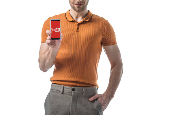 cropped view of man with hand in pocket holding smartphone with youtube app on screen isolated on white