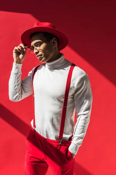 Fashionable Mixed Race Man Hat Suspenders Holding Glasses While Posing — Stock Photo, Image