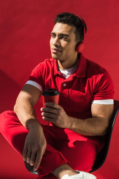 Stylish Mixed Race Man Headphones Sitting Holding Coffee Posing Red — Stock Photo, Image