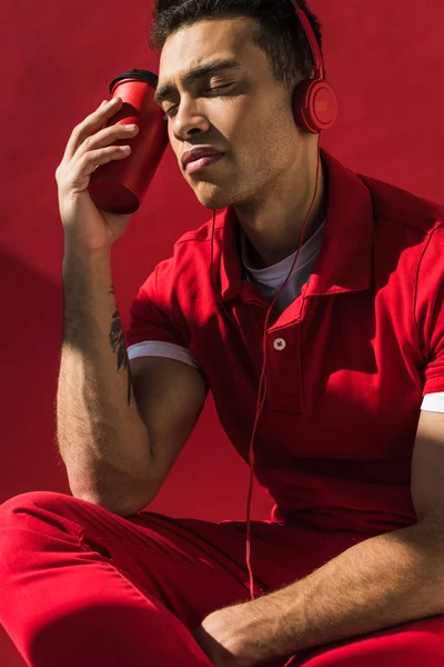 Stylish Mixed Race Man Headphones Holding Coffee Posing Red — Stock Photo, Image